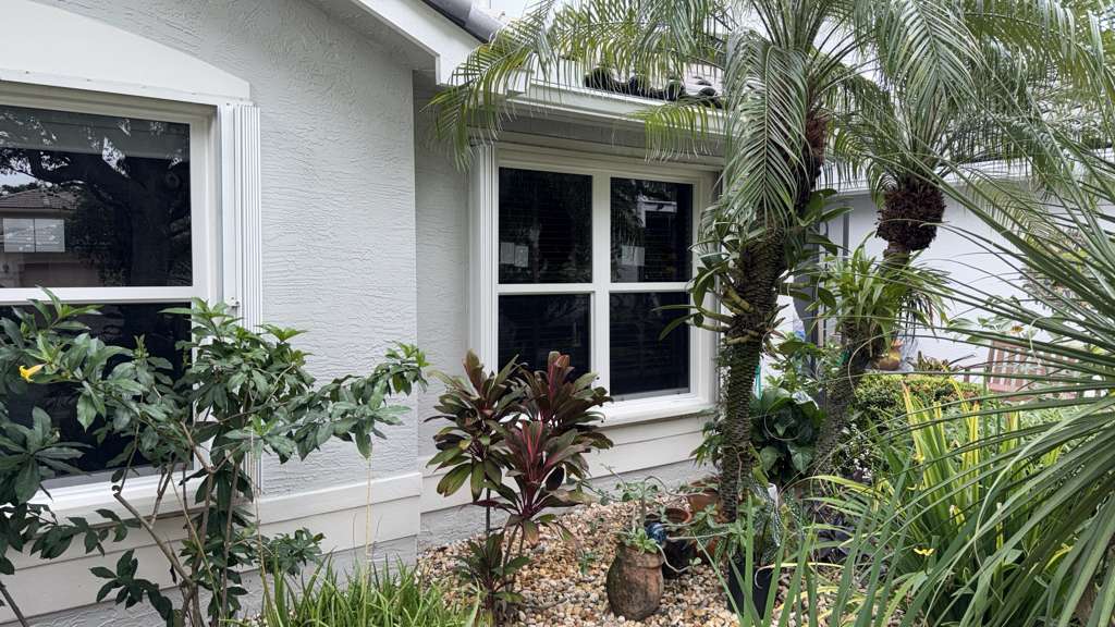Residential impact windows South Florida home with tropical landscaping